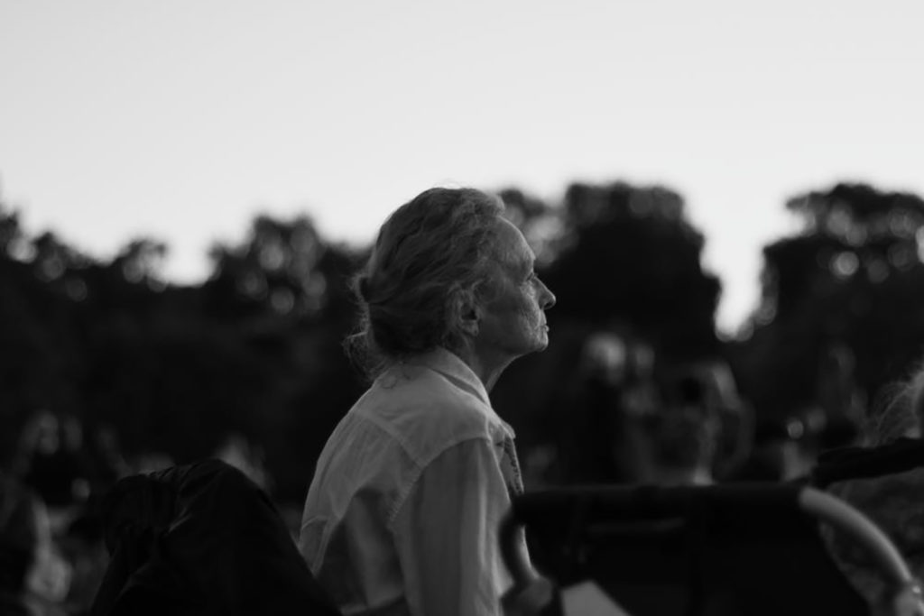 Black and white photo of an elderly woman looking at the sky
