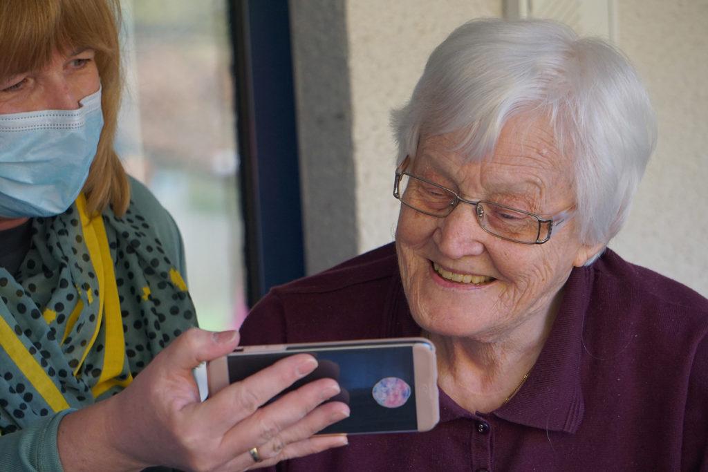 Elderly woman smiling at phone