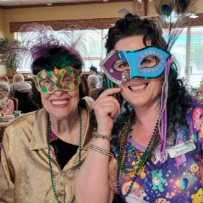 Cascades of Tucson resident and caregiver celebrating Mardi Gras with Mardi Gras masks
